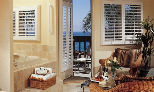 Plantation shutters on casement windows in a lakefront home.